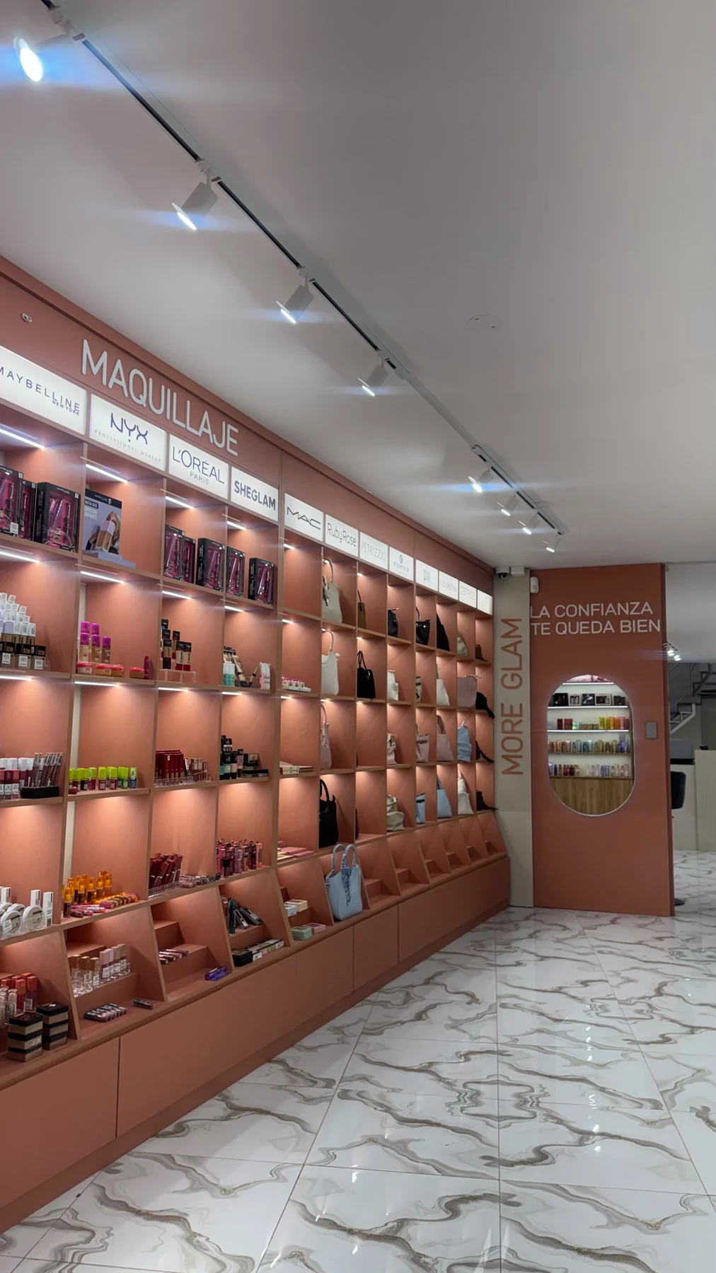 Interior real de Bella Glow: vitrinas de maquillaje en tonos terracota y crema